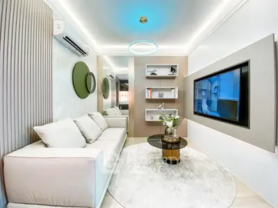 Modern living room with sleek design, featuring a cozy sofa, stylish decor, and a wall-mounted TV.