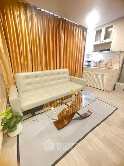 Modern living room with elegant sofa and stylish glass coffee table, featuring luxurious curtains and chic decor.