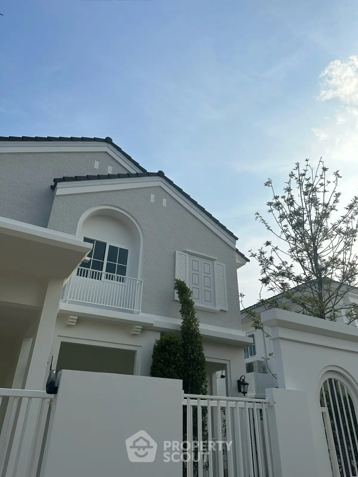 Elegant modern house exterior with white facade and stylish balcony, perfect for luxury living.