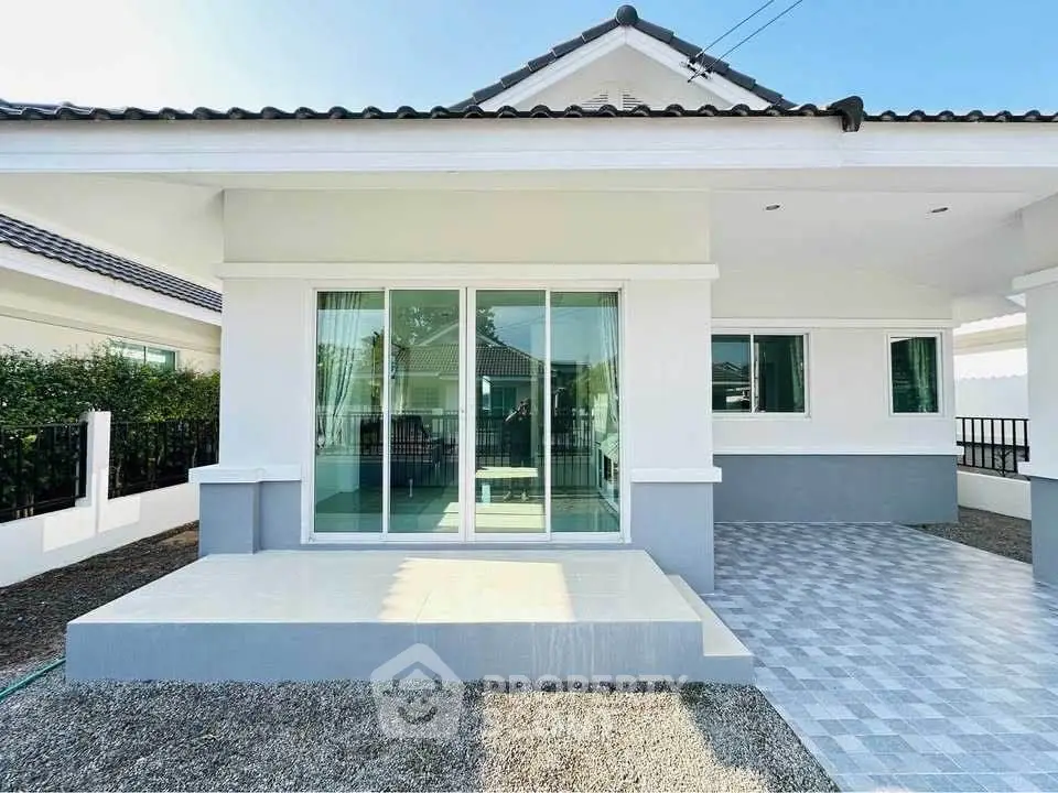 Charming modern house exterior with spacious patio and sleek sliding glass doors.