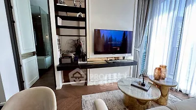 Modern living room with elegant decor and large windows offering natural light.