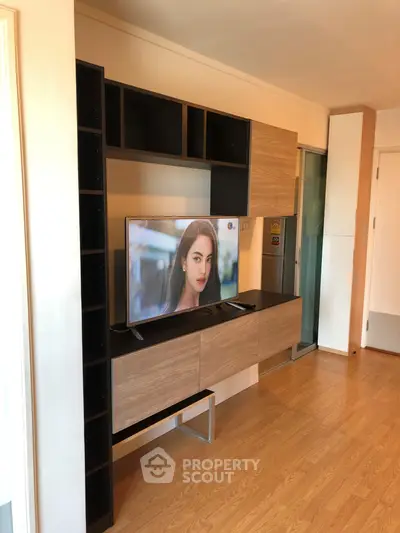 Modern living room with sleek TV unit and wooden flooring, perfect for stylish urban living.