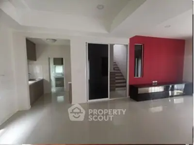 Spacious modern living room with sleek design and vibrant red accent wall