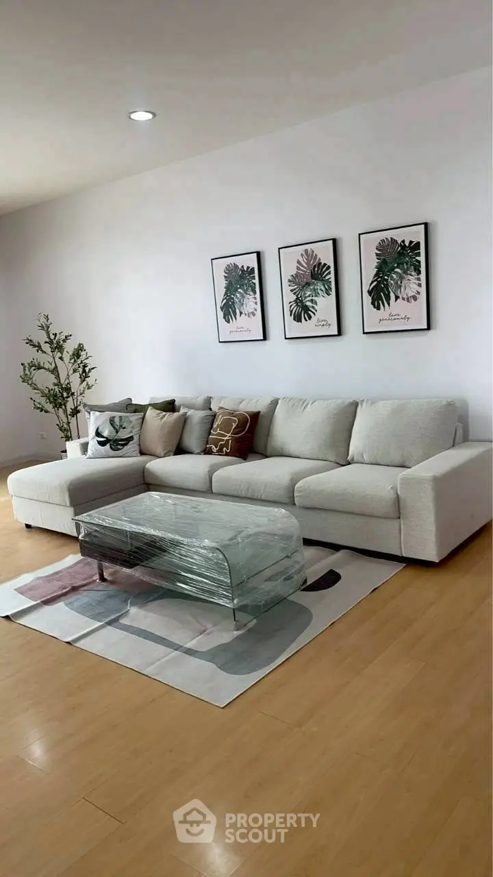 Stylish living room with modern white sofa and glass coffee table, perfect for relaxation.