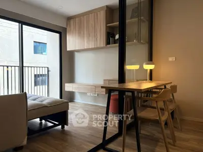 Modern living room with wooden flooring, stylish furniture, and large windows for natural light.