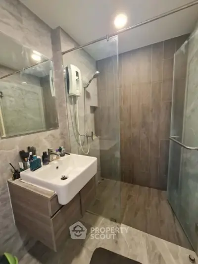 Modern bathroom with glass shower and sleek vanity in contemporary apartment