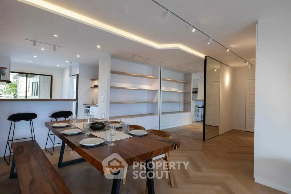 Modern dining area with wooden table and open kitchen layout