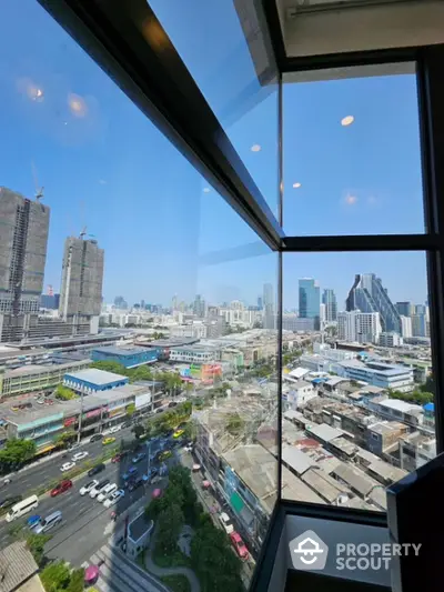 Stunning cityscape view from a modern high-rise building window, showcasing urban skyline and bustling streets.