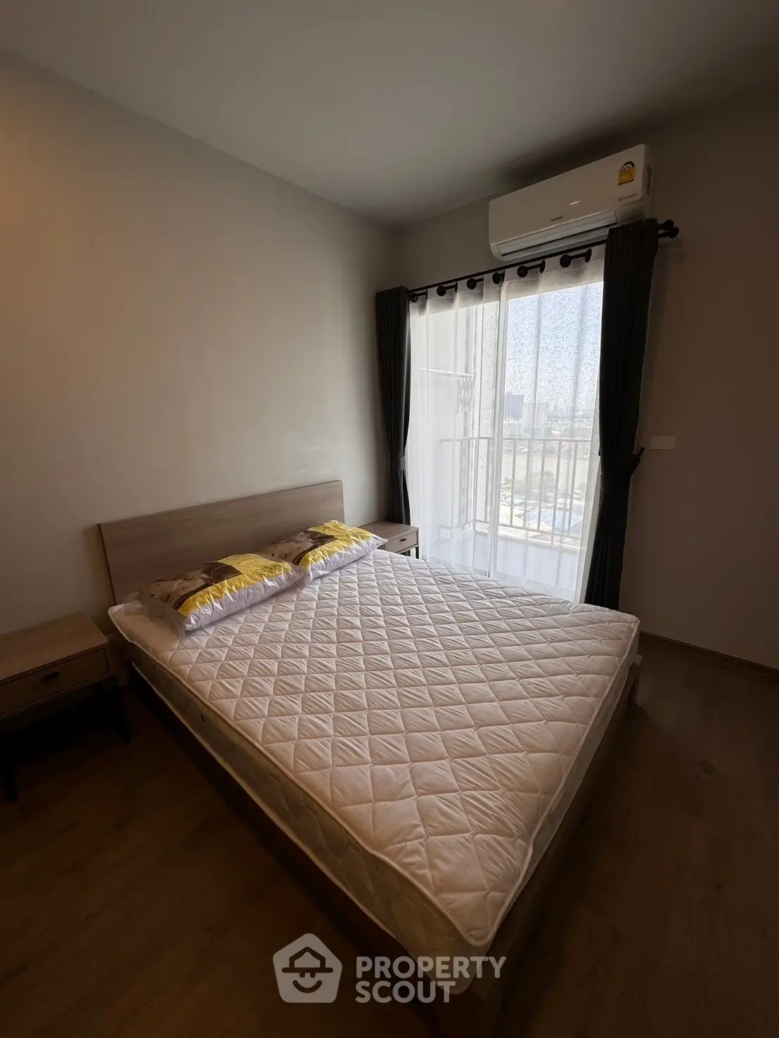 Cozy bedroom with balcony view and air conditioning in modern apartment