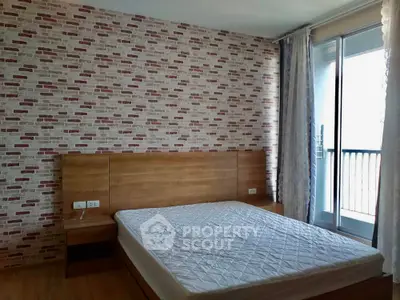 Modern bedroom with brick accent wall and balcony access
