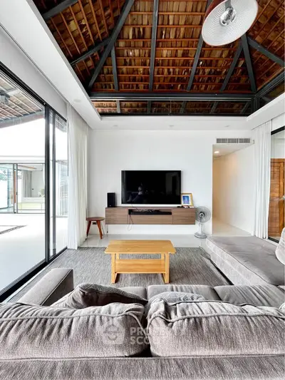 Spacious living room with modern decor and large windows offering natural light.