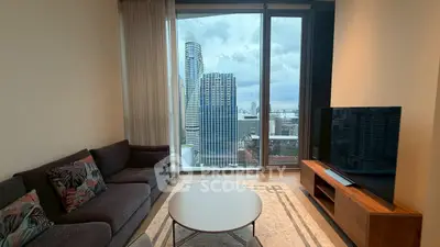 Modern living room with stunning city view through large windows, featuring cozy sofa and sleek TV setup.