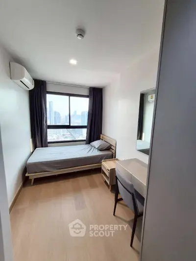 Modern bedroom with city view, featuring sleek furniture and natural light.
