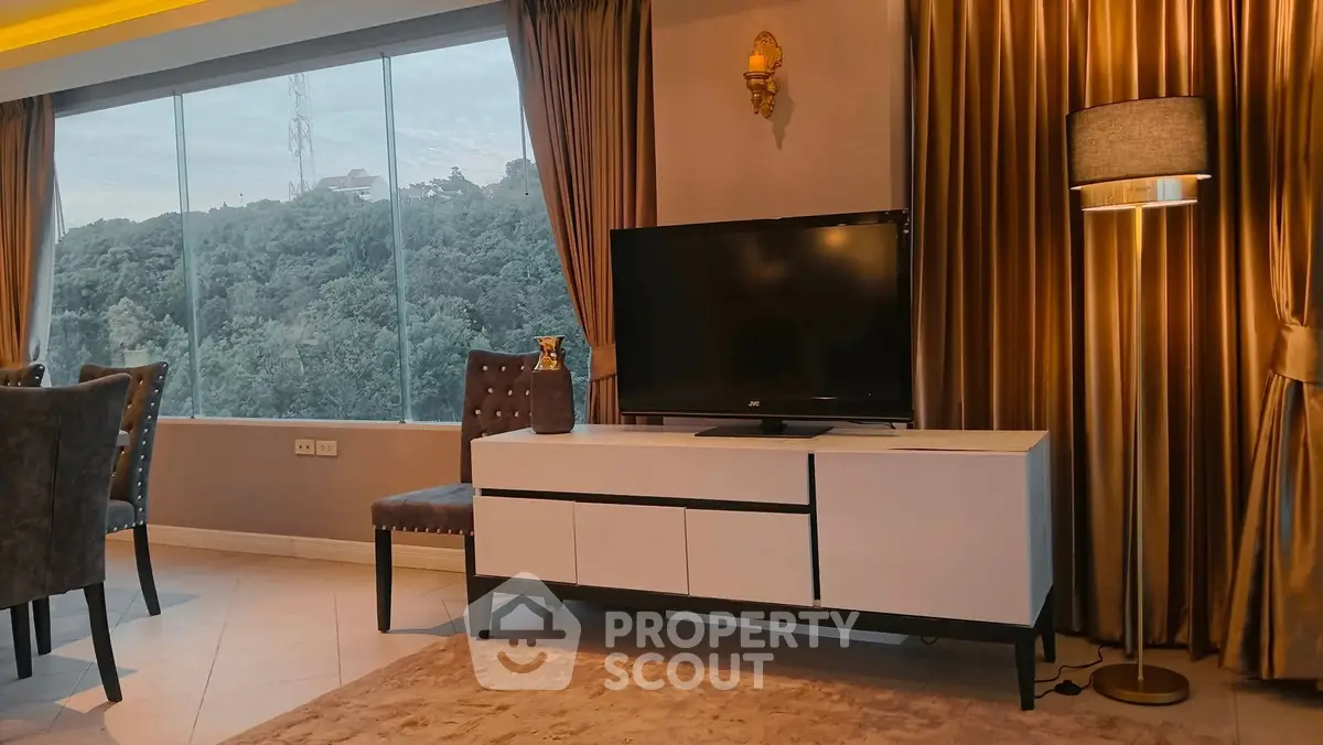 Luxurious living room with scenic view, elegant decor, and modern entertainment setup.