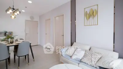 Modern living room with stylish decor and dining area, featuring elegant lighting and cozy seating.