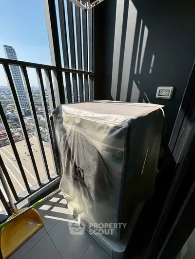 High-rise balcony with city view and covered washing machine, perfect for urban living.