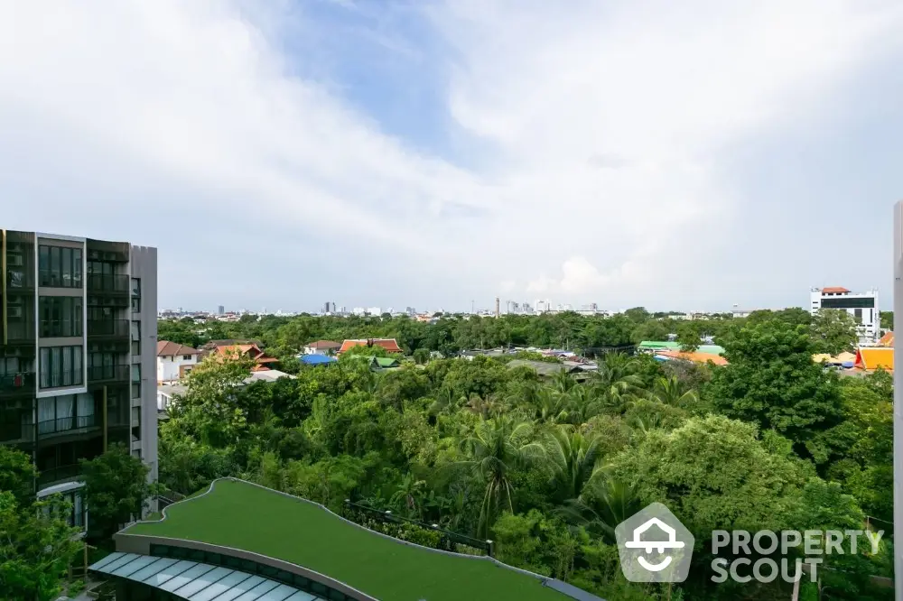 Stunning panoramic view from high-rise building overlooking lush greenery and cityscape.