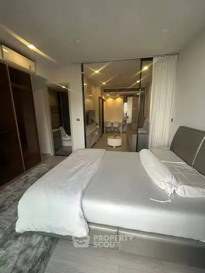 Luxurious bedroom with modern decor and open layout leading to living area, perfect for stylish urban living.