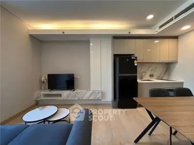 Modern living room with sleek kitchen, stylish furniture, and elegant lighting in a contemporary apartment.