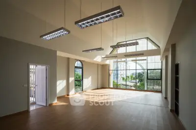 Spacious modern living room with high ceilings and large windows offering abundant natural light.