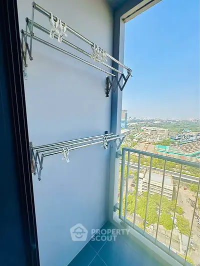 Compact balcony with drying racks and city view, perfect for urban living.