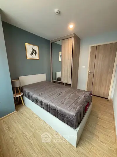 Modern bedroom with stylish decor and wooden flooring in a cozy apartment.