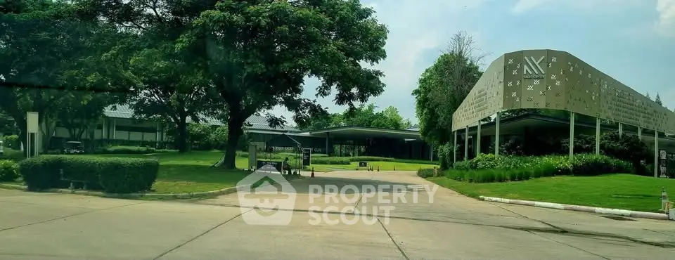 Modern building entrance with lush greenery and spacious driveway