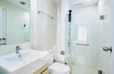 Modern bathroom with glass shower and sleek fixtures in a contemporary home.