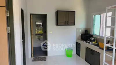 Modern kitchen with sleek cabinetry and compact design, featuring a convenient open layout and natural light.