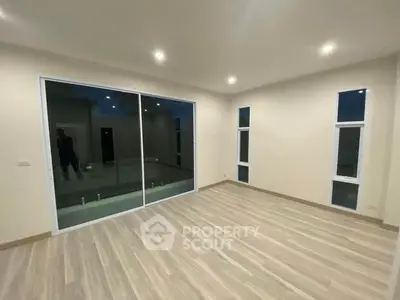 Spacious modern living room with large sliding glass doors and elegant flooring.