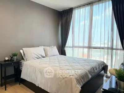 Modern bedroom with large window and stylish decor in a high-rise apartment.