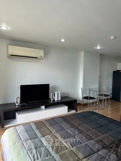Modern studio apartment with sleek furniture and air conditioning, perfect for urban living.