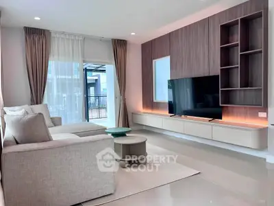 Modern living room with sleek design, large TV, and elegant furniture in a bright, airy space.