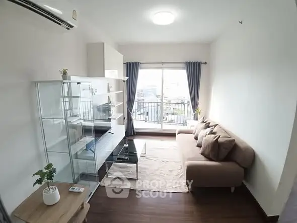 Bright living room with modern furniture and city view balcony in a cozy apartment.