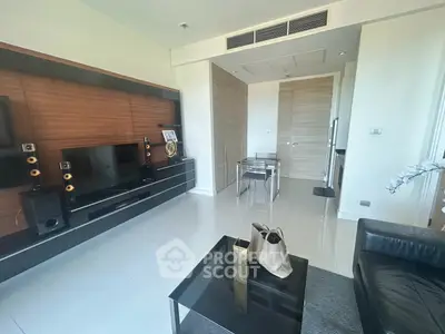 Modern living room with sleek entertainment center and dining area, featuring contemporary decor and neutral tones.