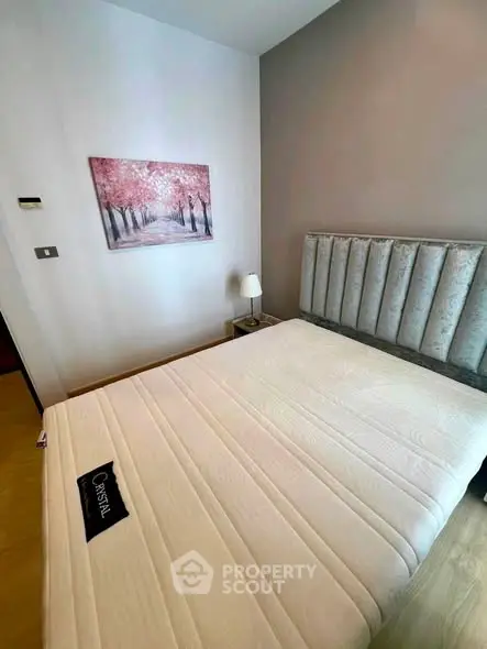 Cozy bedroom with elegant decor and plush headboard in modern apartment.