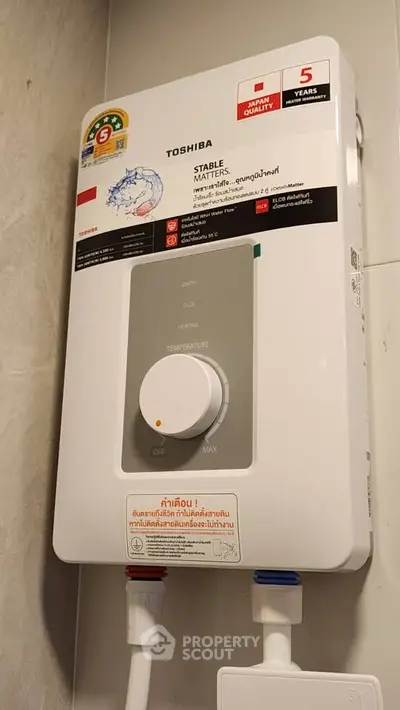 Modern water heater with energy efficiency label in a bathroom setting.