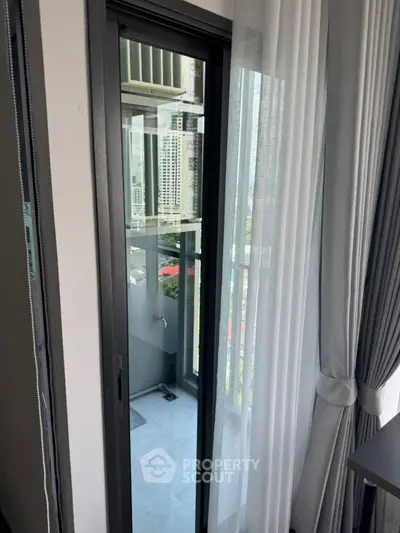 Modern apartment balcony with city view and sliding glass door