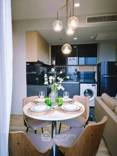 Modern kitchen with dining area, featuring elegant lighting and built-in appliances.