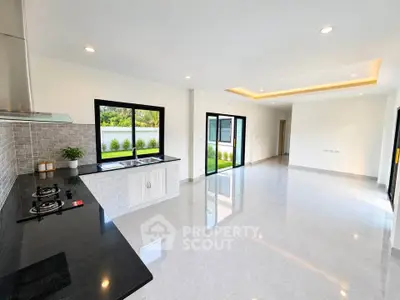 Spacious open-plan kitchen and living area with modern finishes and garden view.