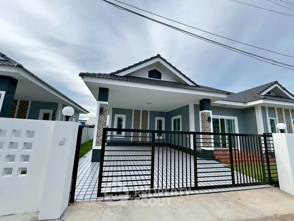 Modern single-story house with gated driveway and tiled exterior