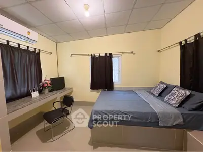 Cozy bedroom with modern decor and workspace, perfect for relaxation and productivity.