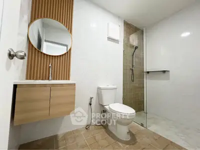 Modern bathroom with sleek design, featuring a glass shower and stylish vanity.