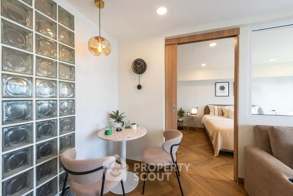 Modern open-plan living room with stylish dining area and cozy bedroom view.