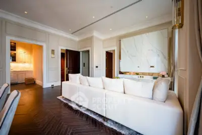 Luxurious living room with elegant decor and modern design, featuring a spacious white sofa and stylish lighting.