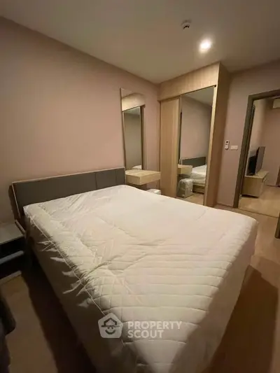 Cozy bedroom with modern furnishings and ample natural light, perfect for relaxation and comfort.