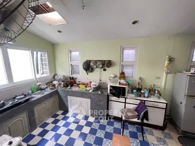 Charming kitchen with checkered floor and ample natural light, featuring a cozy, functional layout.
