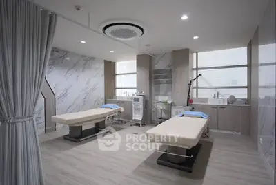 Luxurious modern spa room with two massage tables and elegant marble walls.