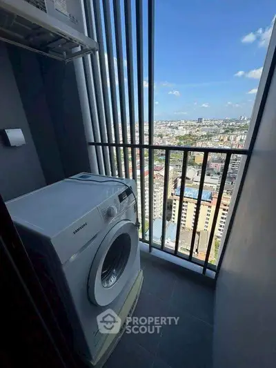 High-rise apartment balcony with washing machine and stunning city view.