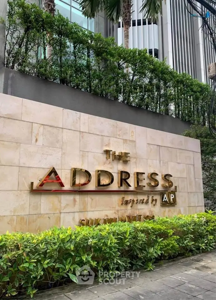 Luxurious building entrance with elegant signage and lush greenery at The Address by AP.
